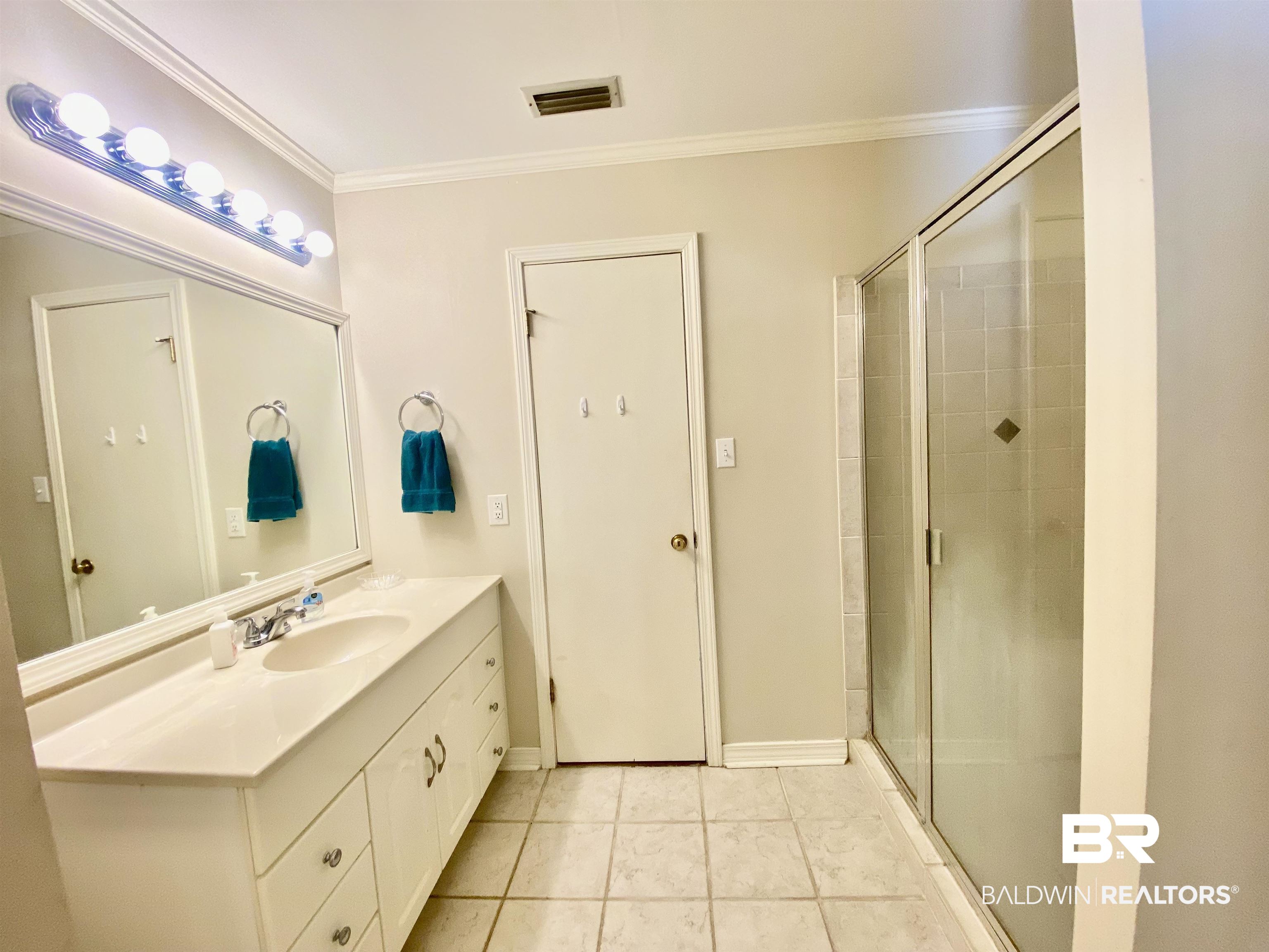 272 Longleaf Circle Monroeville, AL 36460 - Photo 20 of 38 Bathroom featuring vanity, ornamental molding, a shower with door, and tile patterned floors