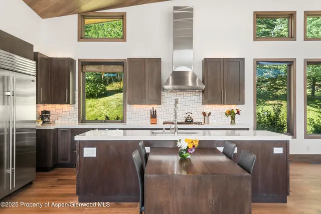 a kitchen with stainless steel appliances granite countertop a sink a stove and a refrigerator