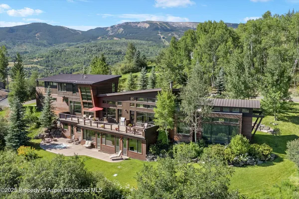 an aerial view of a house with a garden and a mountain view