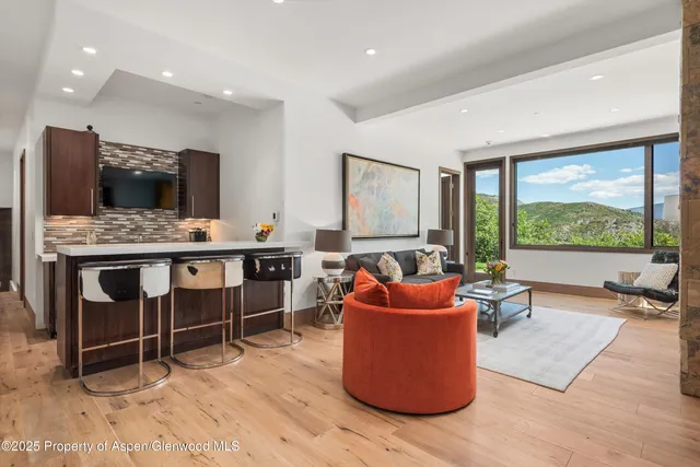 a living room with fireplace furniture and a large window