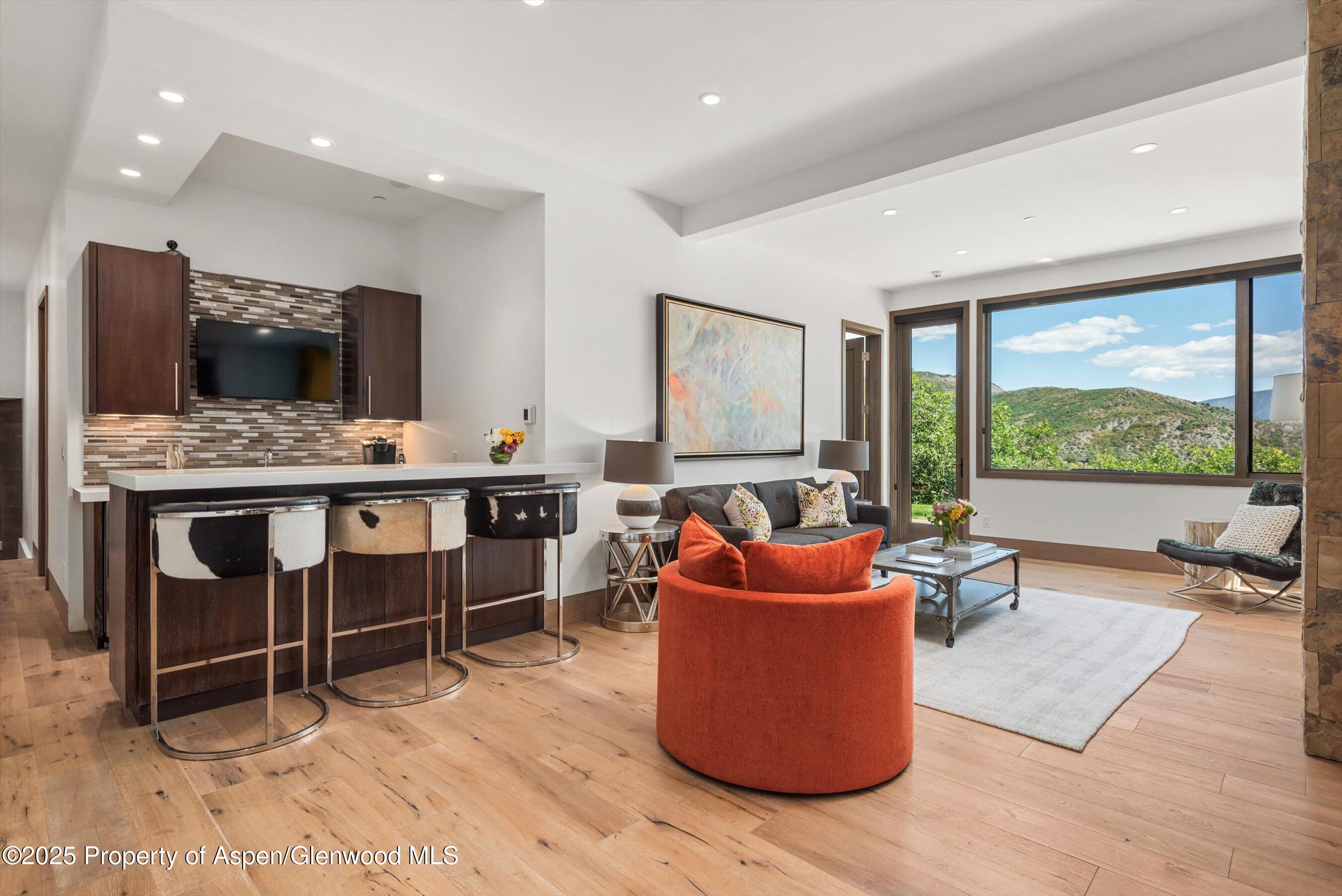 272 Oak Ridge Road Snowmass Village, CO 81615 - Photo 22 of 54 a living room with furniture a flat screen tv and a large window