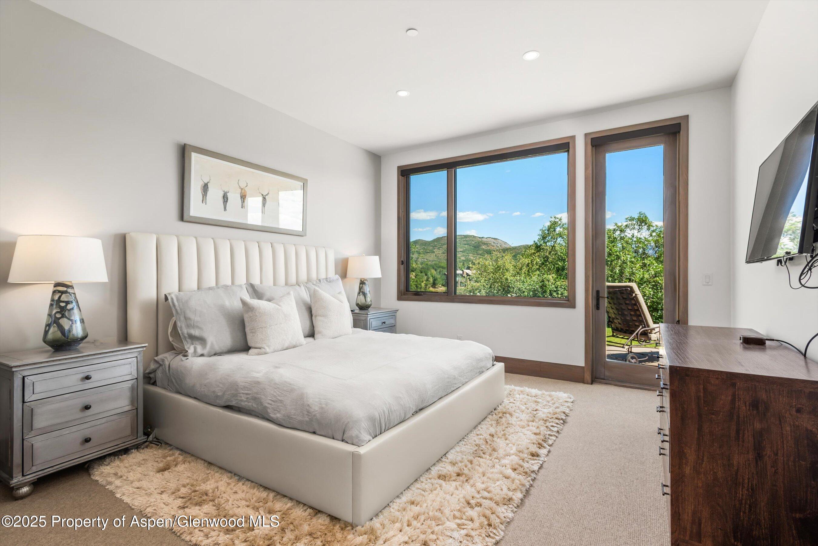 272 Oak Ridge Road Snowmass Village, CO 81615 - Photo 25 of 54 a spacious bedroom with a large bed and a large window