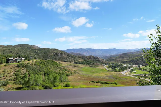 a view of a balcony with table and chairs under an umbrella