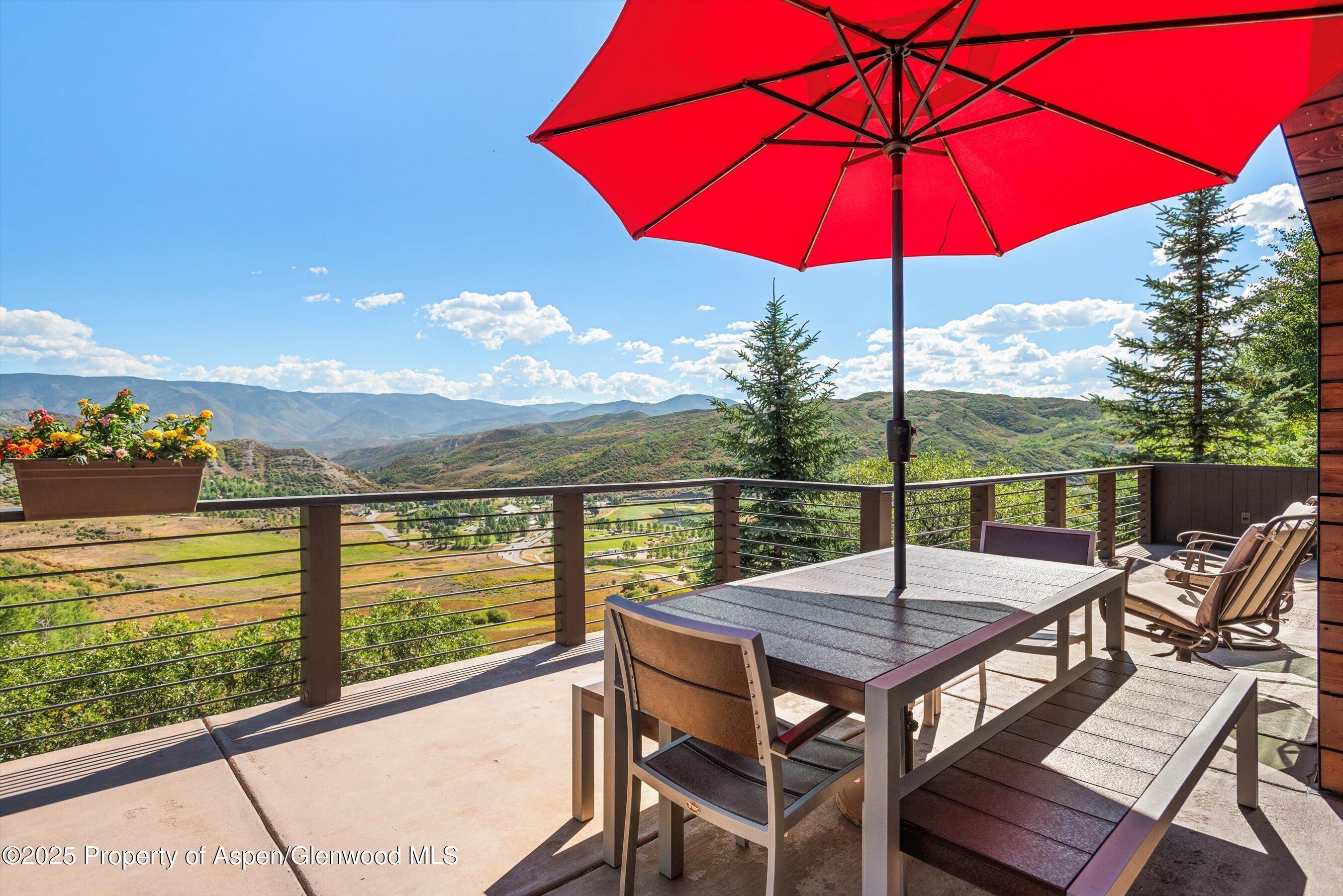 272 Oak Ridge Road Snowmass Village, CO 81615 - Photo 44 of 54 a view of a balcony with table and chairs under an umbrella