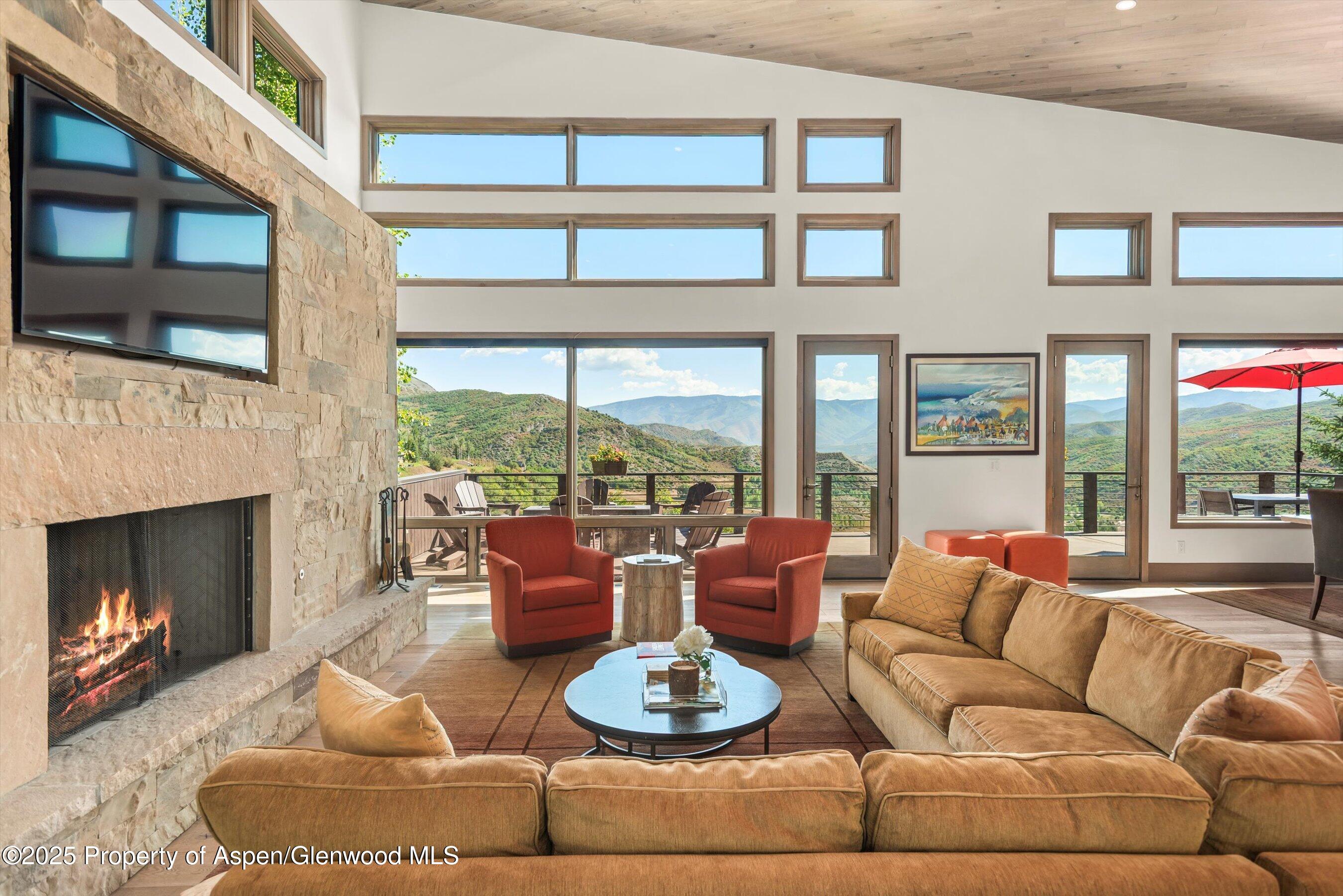 272 Oak Ridge Road Snowmass Village, CO 81615 - Photo 6 of 54 a living room with furniture a fireplace and a large window