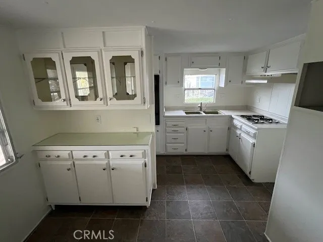 a front view of house with wooden fence next to a road
