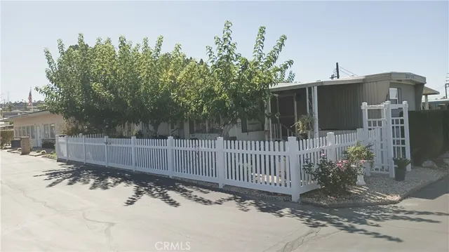 a view of a house with a small yard and wooden fence