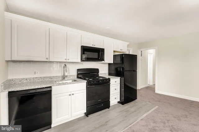 a kitchen with a stove top oven and refrigerator