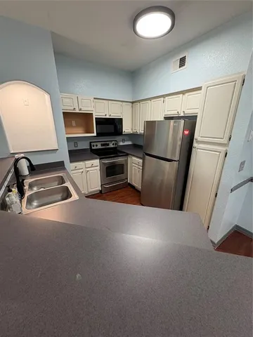 a kitchen with a refrigerator and a sink