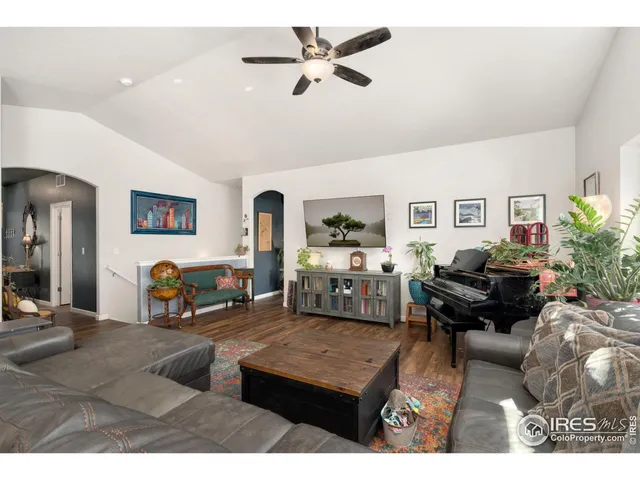 a living room with furniture gym equipment and a ceiling fan