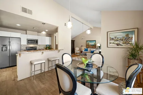 a kitchen with kitchen island granite countertop a refrigerator cabinets and wooden floor