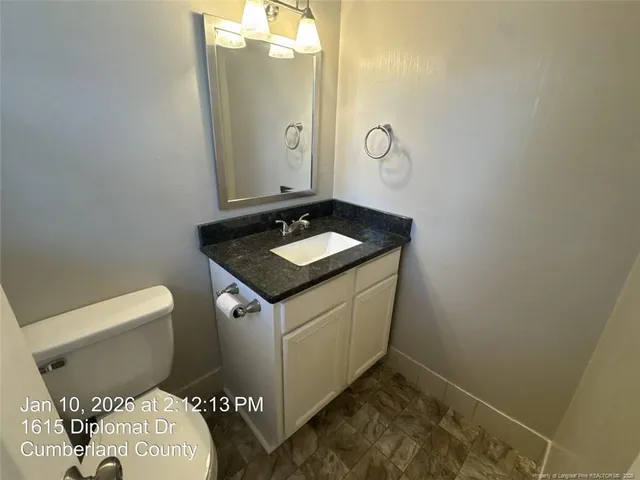 a bathroom with a granite countertop sink and a mirror