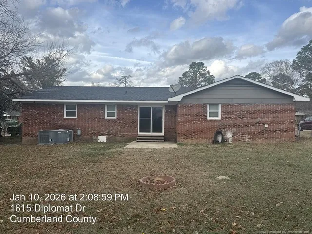 a brick house with a yard in front of it