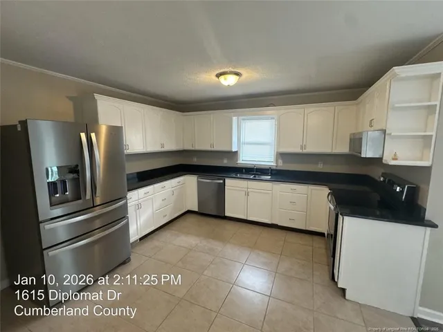 a large kitchen with a stove a sink and a refrigerator