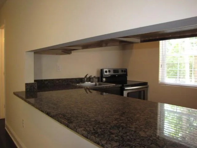 a kitchen with a refrigerator and a stove top oven