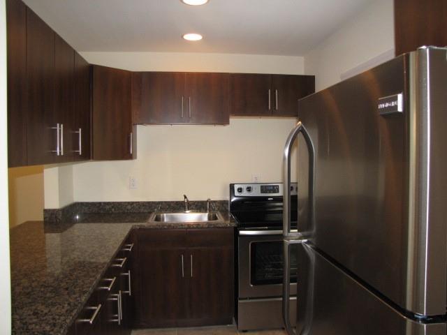 805 Piedmont Avenue Northeast, Unit 4 Atlanta, GA 30308 - Photo 5 of 9 a kitchen with a refrigerator and a stove top oven