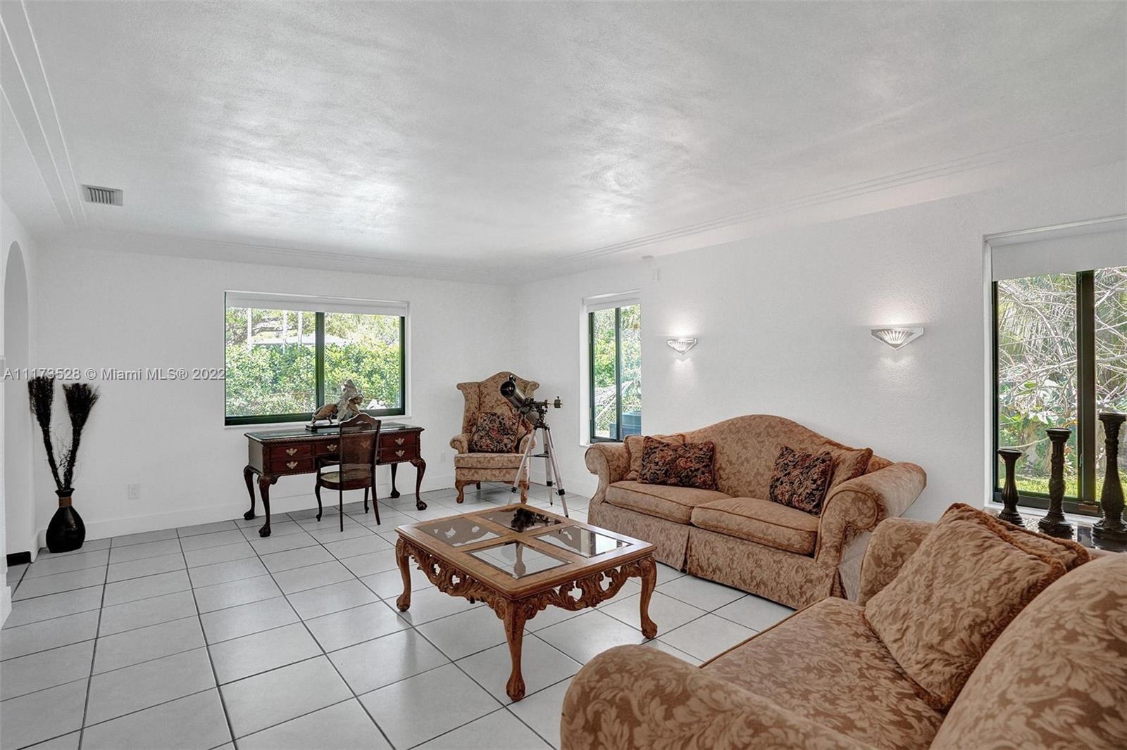 10801 Griffing Boulevard Biscayne Park, FL 33161 - Photo 14 of 77 a living room with furniture and a window