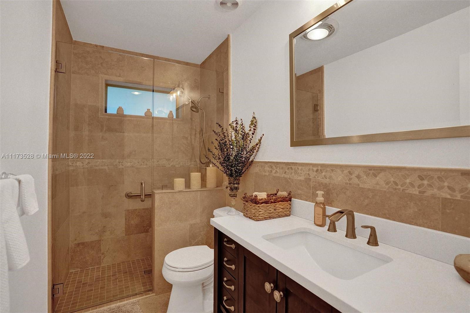 10801 Griffing Boulevard Biscayne Park, FL 33161 - Photo 18 of 77 a bathroom with a granite countertop sink toilet and shower