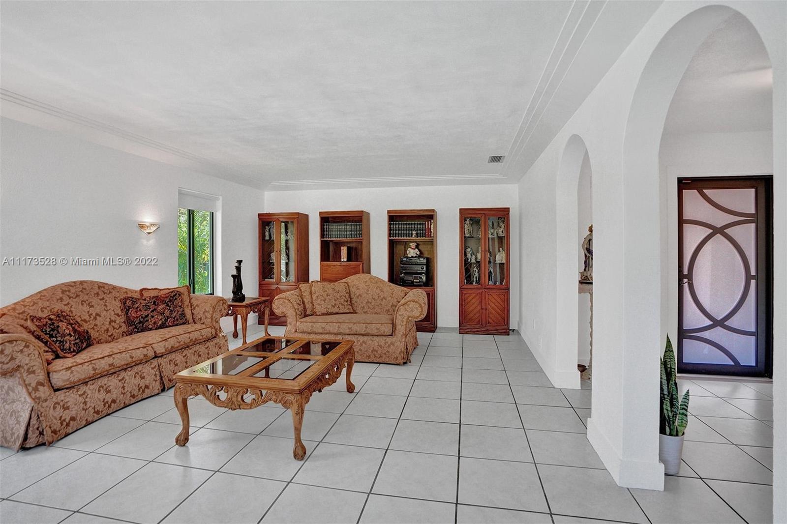 10801 Griffing Boulevard Biscayne Park, FL 33161 - Photo 20 of 77 a living room with furniture and a window