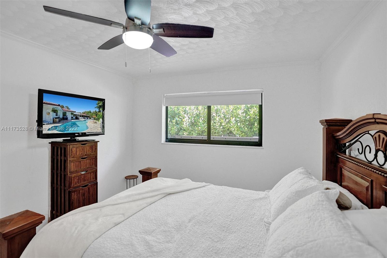 10801 Griffing Boulevard Biscayne Park, FL 33161 - Photo 25 of 77 a bedroom with a bed and a painting on the wall