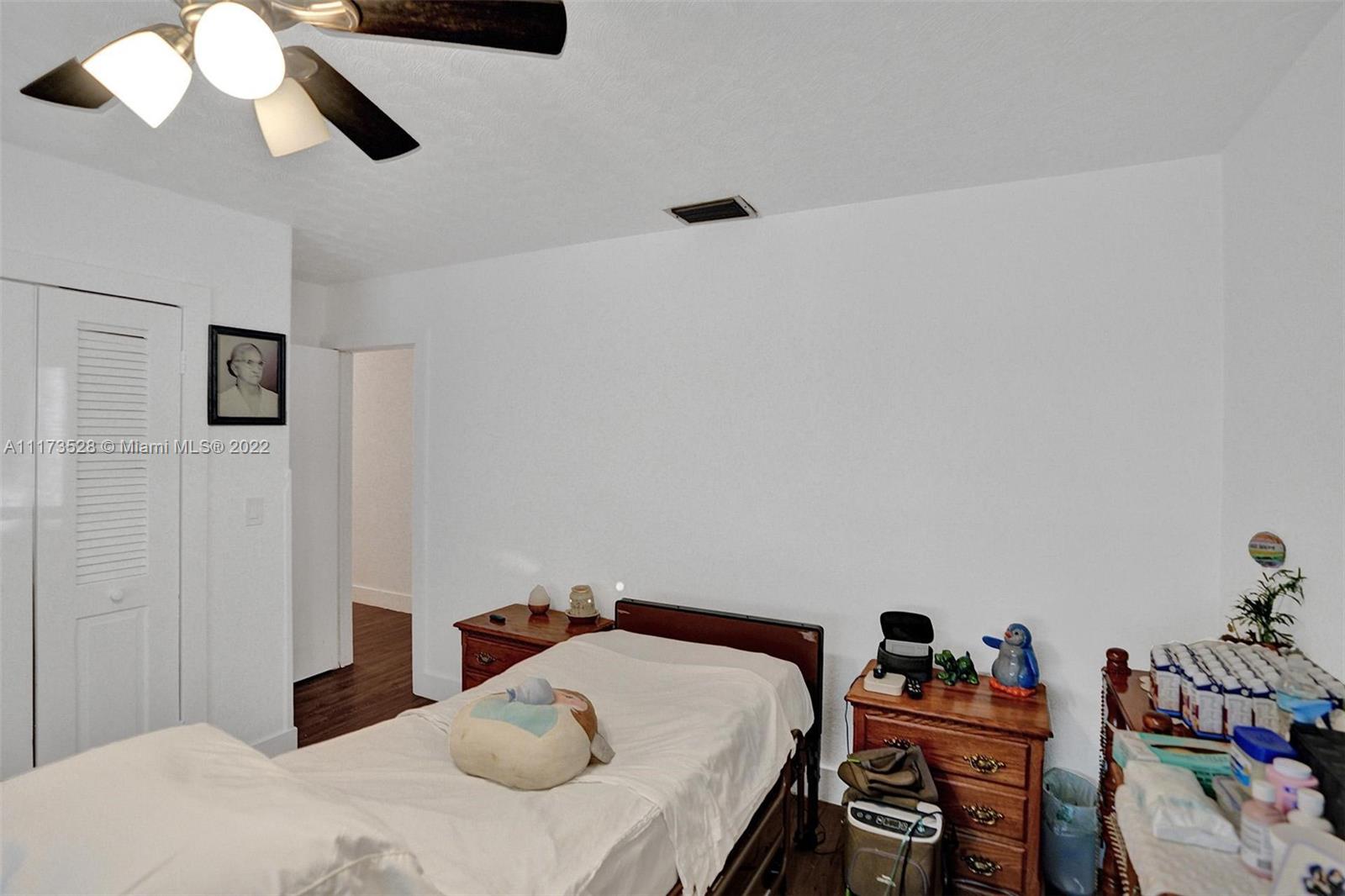 10801 Griffing Boulevard Biscayne Park, FL 33161 - Photo 26 of 77 a bedroom with a bed and a chandelier