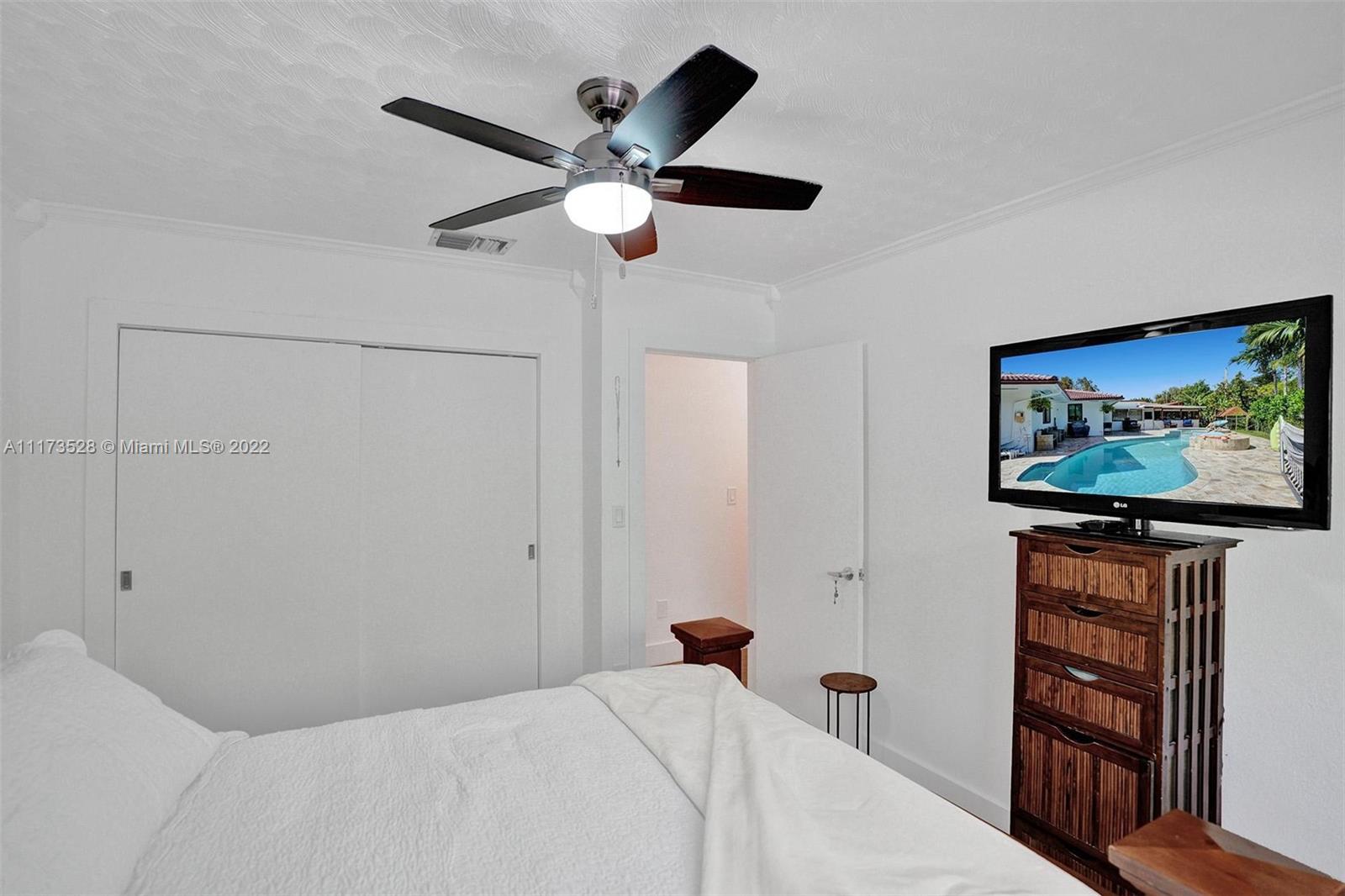 10801 Griffing Boulevard Biscayne Park, FL 33161 - Photo 27 of 77 a bedroom with a bed and a flat screen tv
