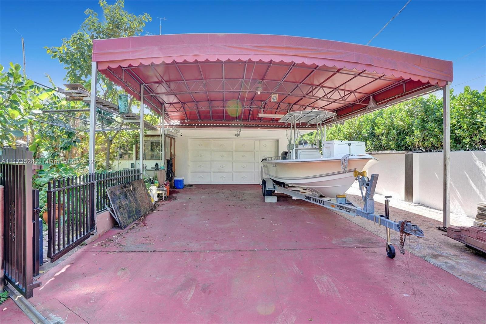 10801 Griffing Boulevard Biscayne Park, FL 33161 - Photo 47 of 77 a patio with a table and chairs under an umbrella