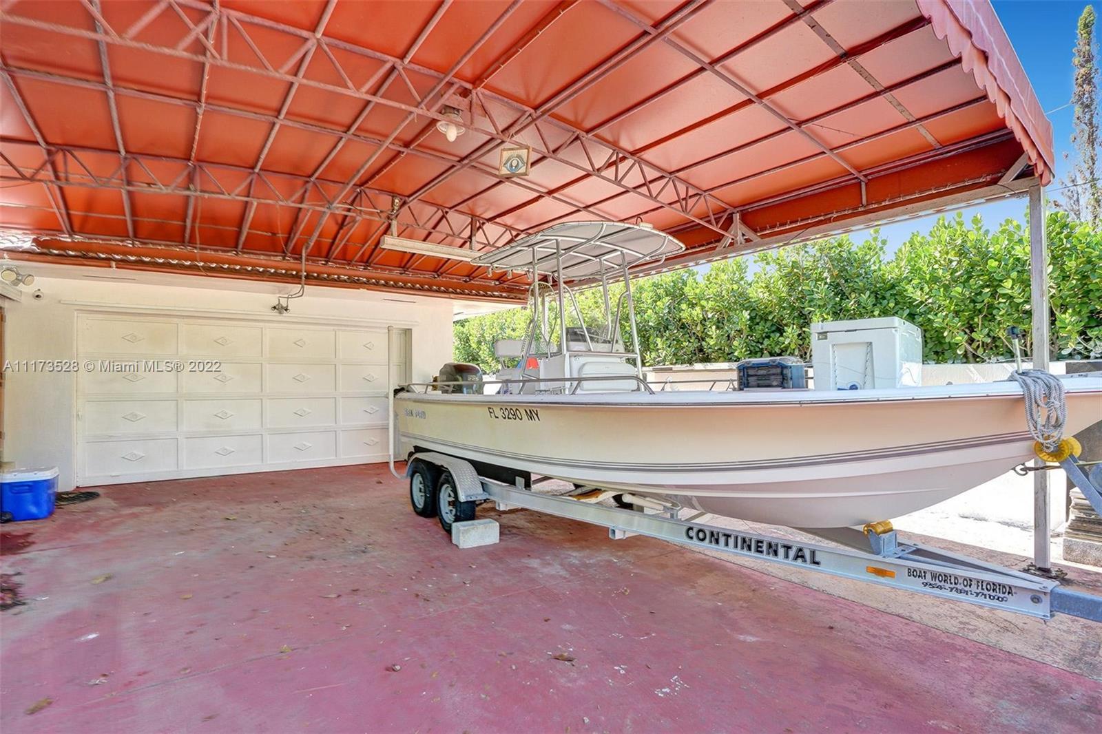 10801 Griffing Boulevard Biscayne Park, FL 33161 - Photo 48 of 77 a view of a patio with a table and chairs under an umbrella