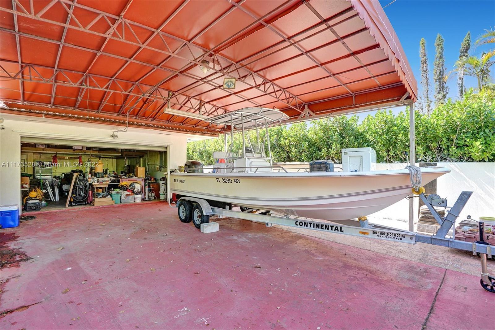 10801 Griffing Boulevard Biscayne Park, FL 33161 - Photo 49 of 77 a view of a patio with table and chairs under an umbrella