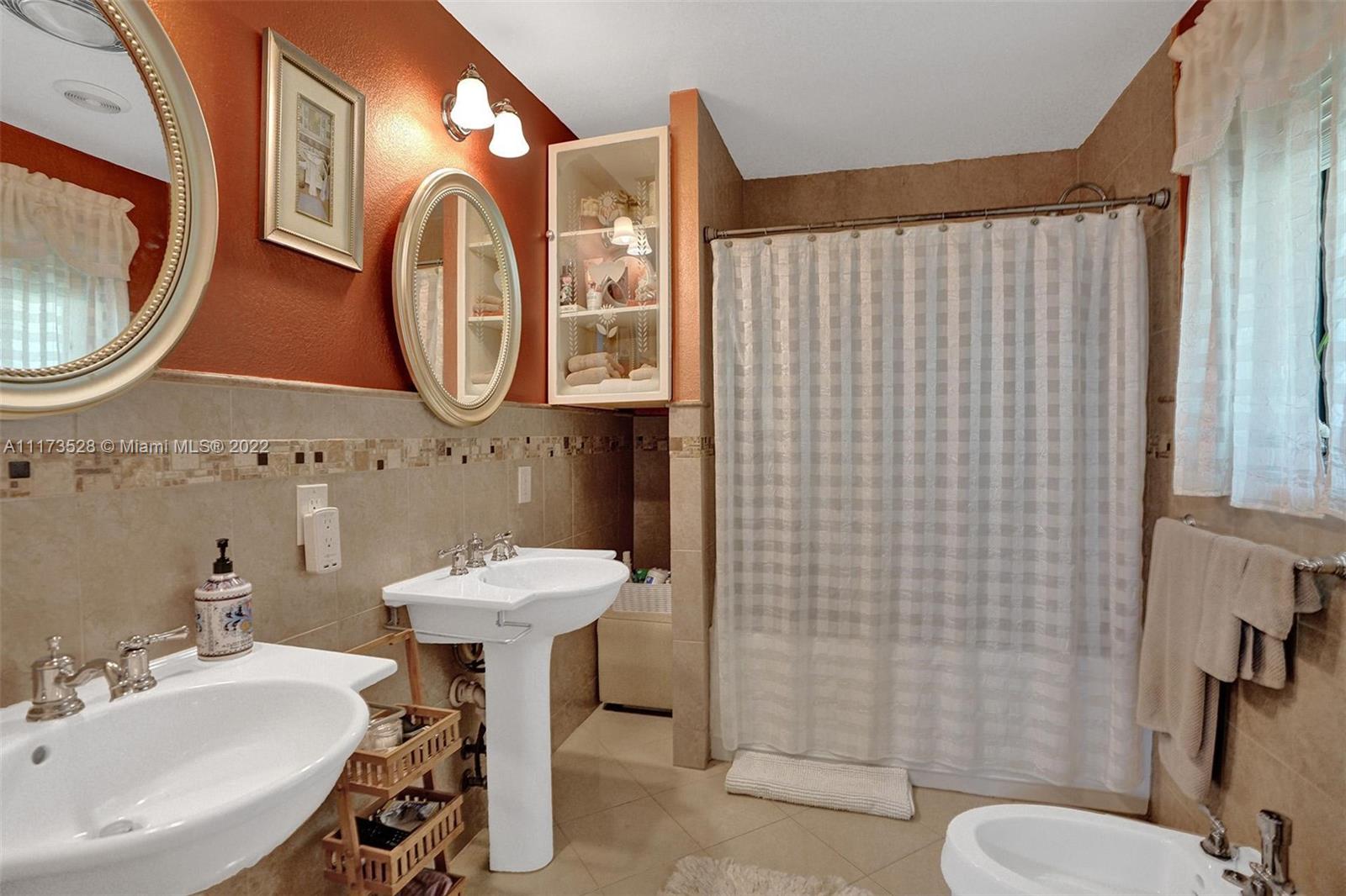 10801 Griffing Boulevard Biscayne Park, FL 33161 - Photo 53 of 77 a bathroom with a sink mirror and toilet