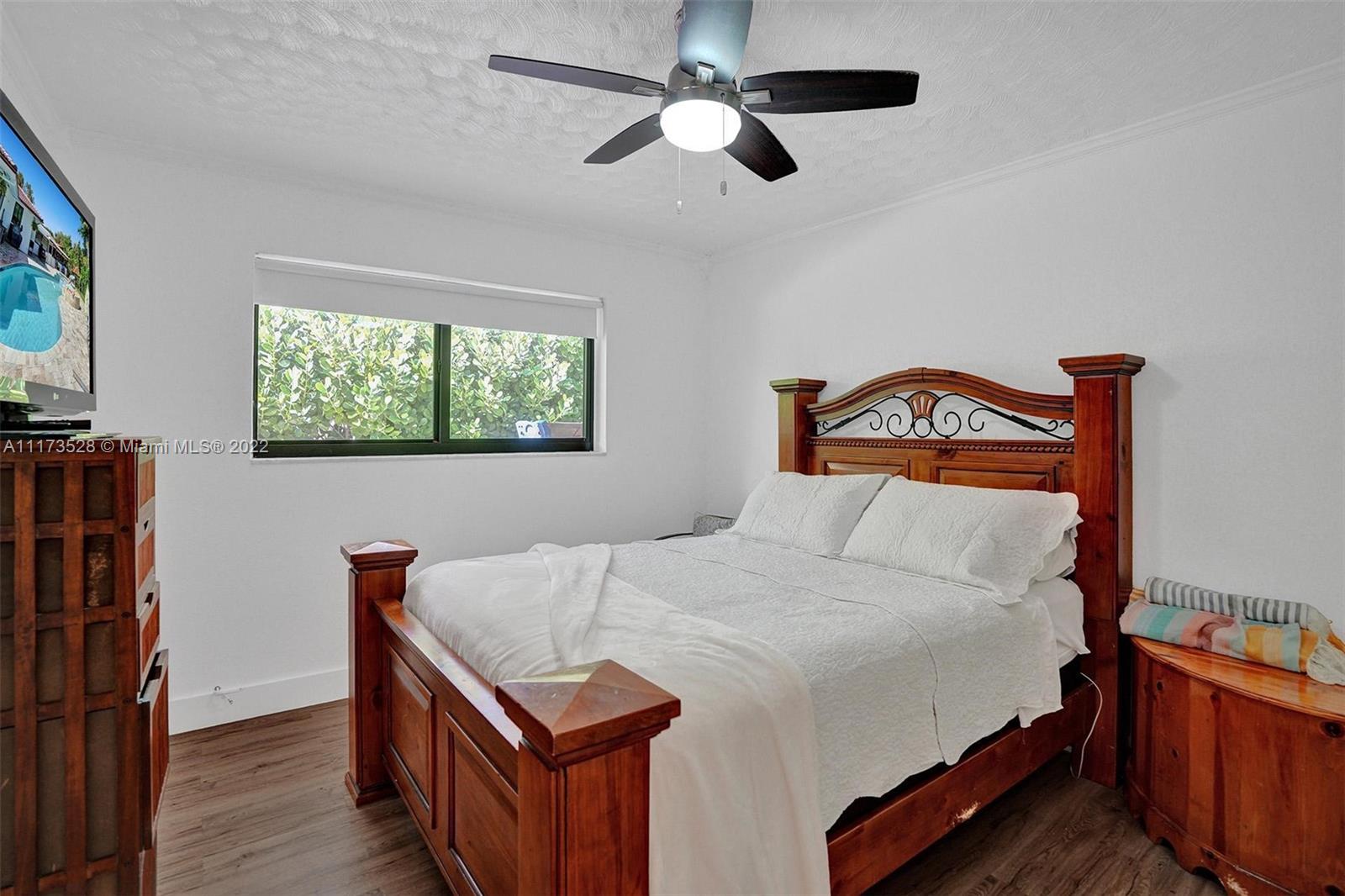 10801 Griffing Boulevard Biscayne Park, FL 33161 - Photo 60 of 77 a bedroom with a bed and a dresser in it