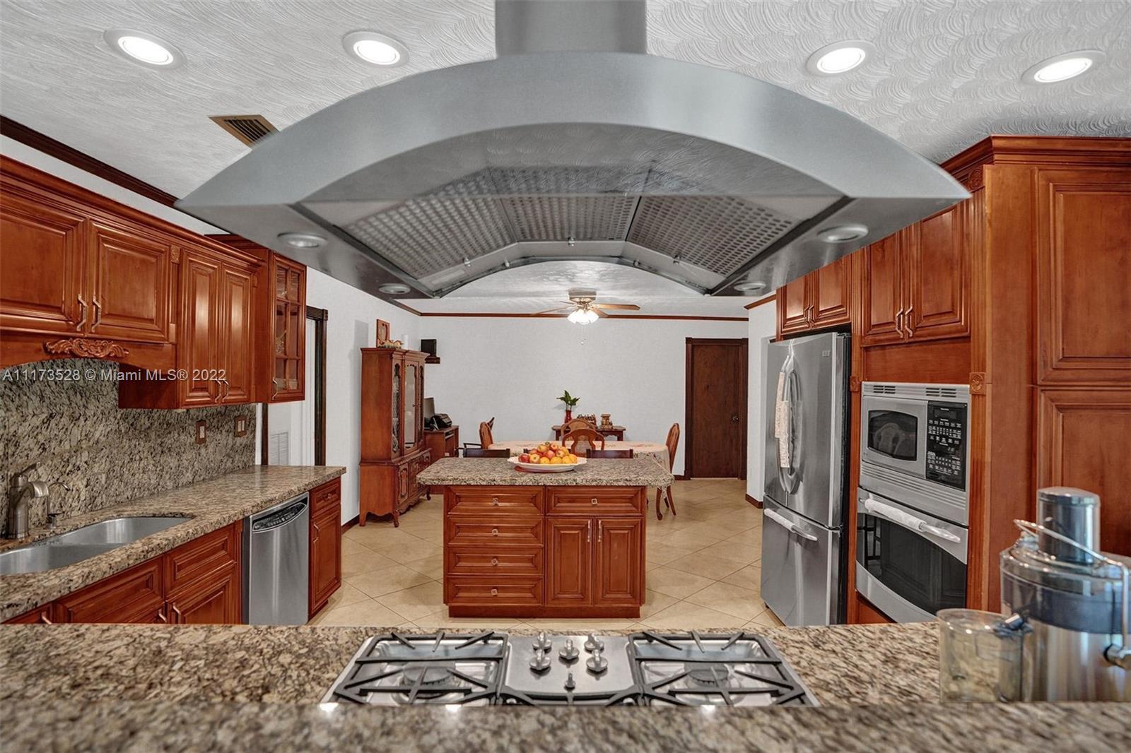 10801 Griffing Boulevard Biscayne Park, FL 33161 - Photo 68 of 77 a kitchen with stainless steel appliances kitchen island granite countertop a sink and cabinets
