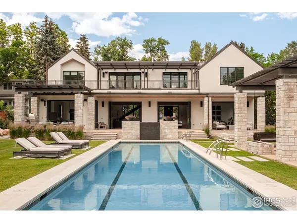a front view of a house with swimming pool and furniture