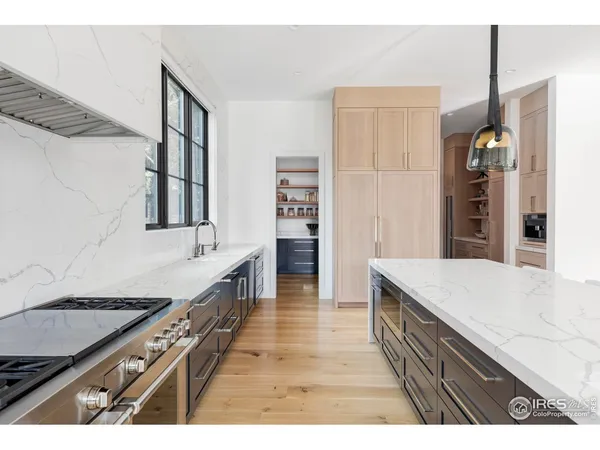 a kitchen with stainless steel appliances granite countertop a lot of counter space and wooden floor