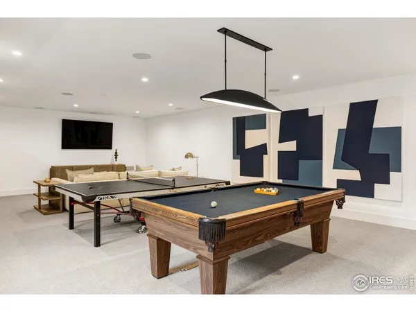 a living room with furniture a flat screen tv and floor to ceiling window