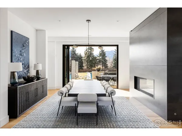 a dining room with wooden floor a chandelier a wooden table and chairs