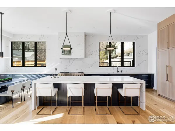 a kitchen with a dining table chairs and white cabinets