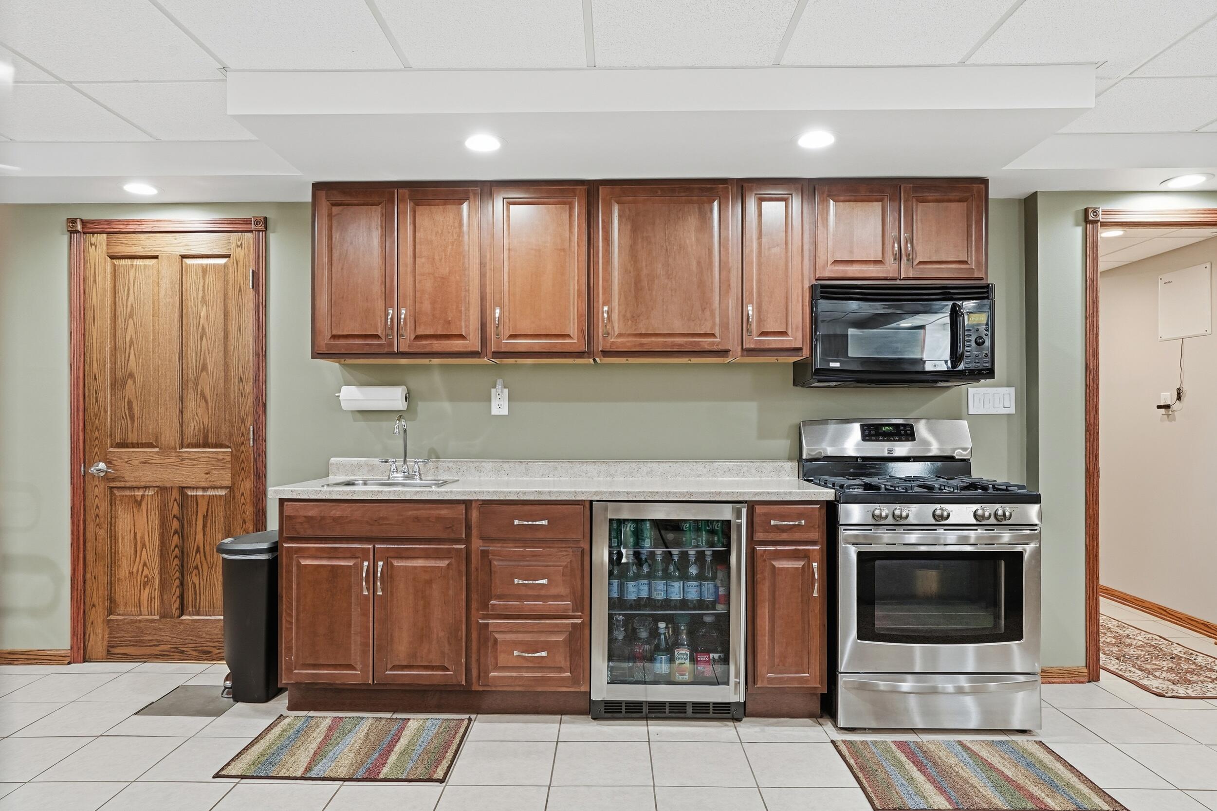 228 Wood Street Crown Point, IN 46307 - Photo 26 of 33 a kitchen with stainless steel appliances granite countertop a stove a sink and a microwave