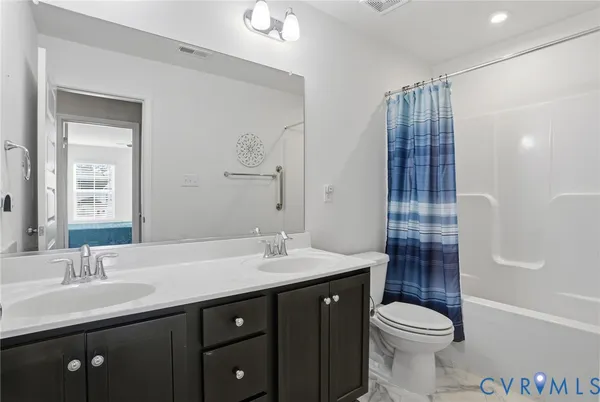 a bathroom with a double vanity sink toilet and shower