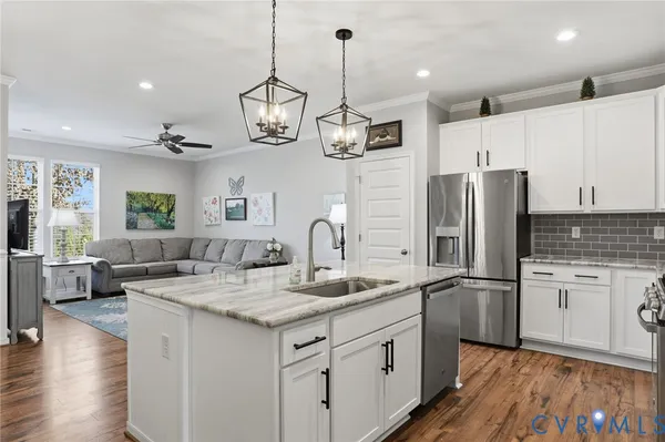 a kitchen with stainless steel appliances granite countertop a sink refrigerator and cabinets