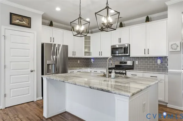 a kitchen with stainless steel appliances granite countertop a refrigerator a stove microwave and cabinets