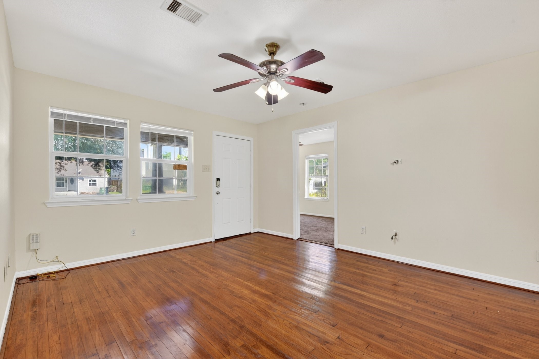 7013 St Augustine Street Houston, TX 77021 - Photo 6 of 35 a view of an empty room with window and wooden floor