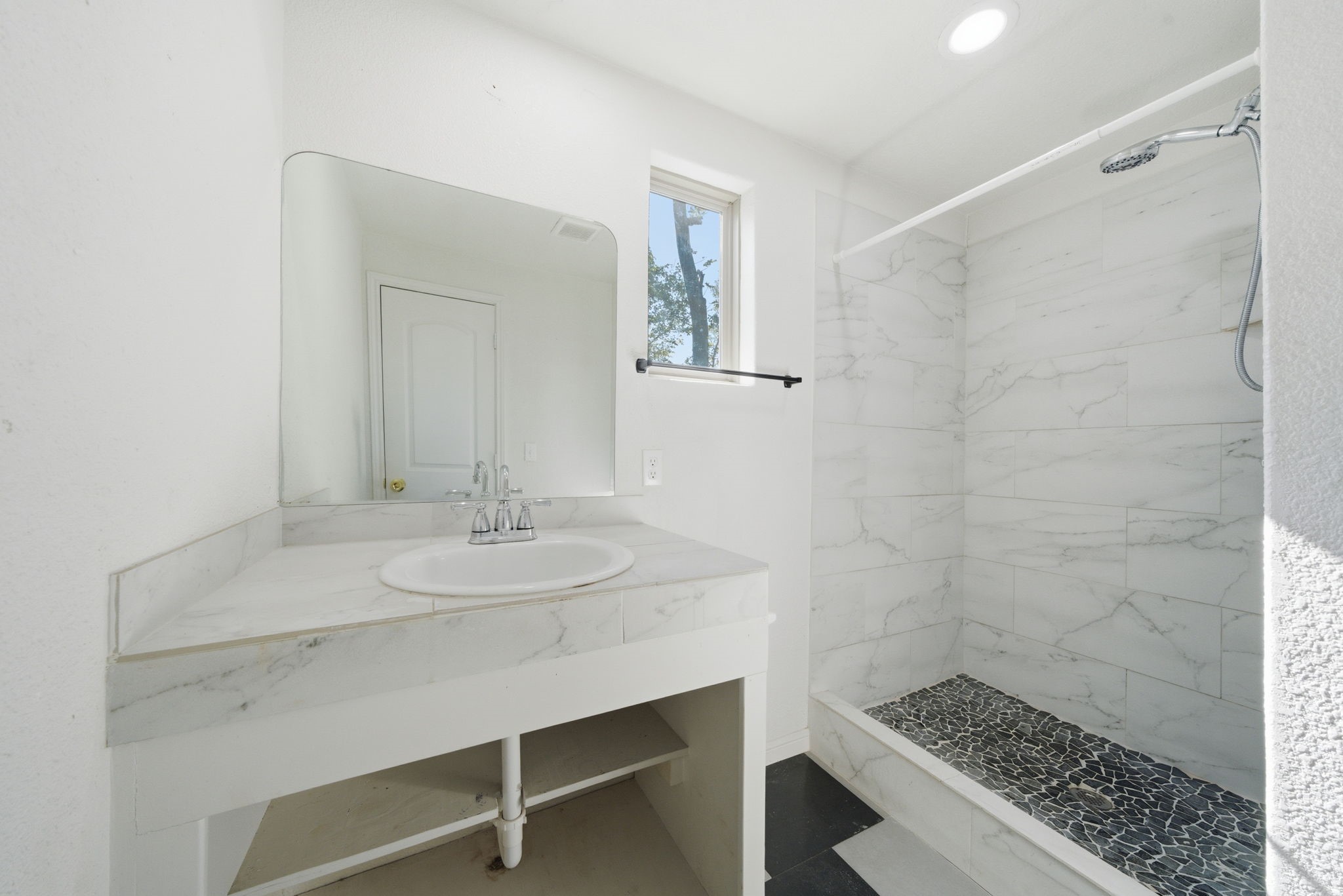 1041 Dolly Wright Street Houston, TX 77088 - Photo 9 of 12 a bathroom with a sink a mirror and a shower