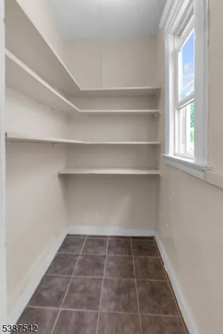 a view of a room with white cabinets and a window