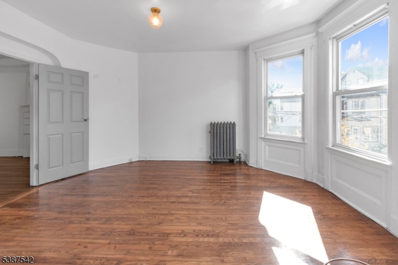 19 North 7th Street, Unit 2 Newark, NJ 07107 - Photo 6 of 21 an empty room with wooden floor and windows