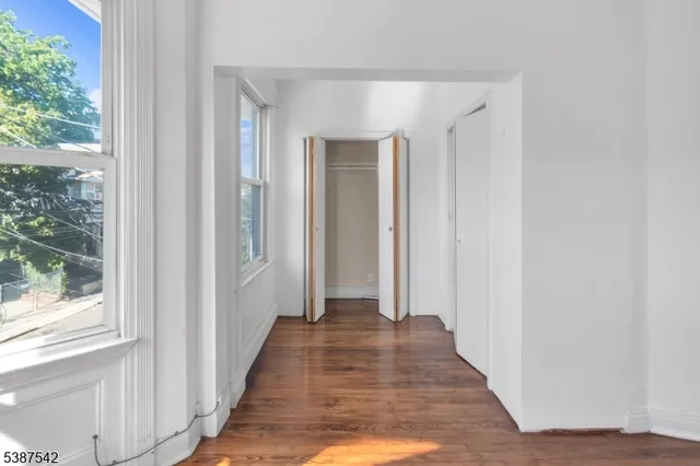 a view of a hallway with wooden floor and windows