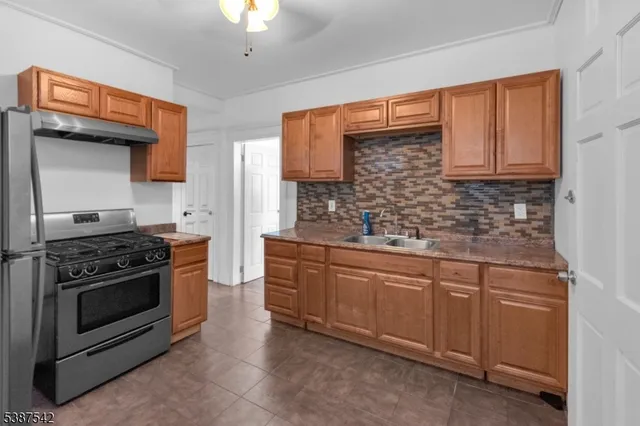 a kitchen with stainless steel appliances granite countertop a stove sink and cabinets