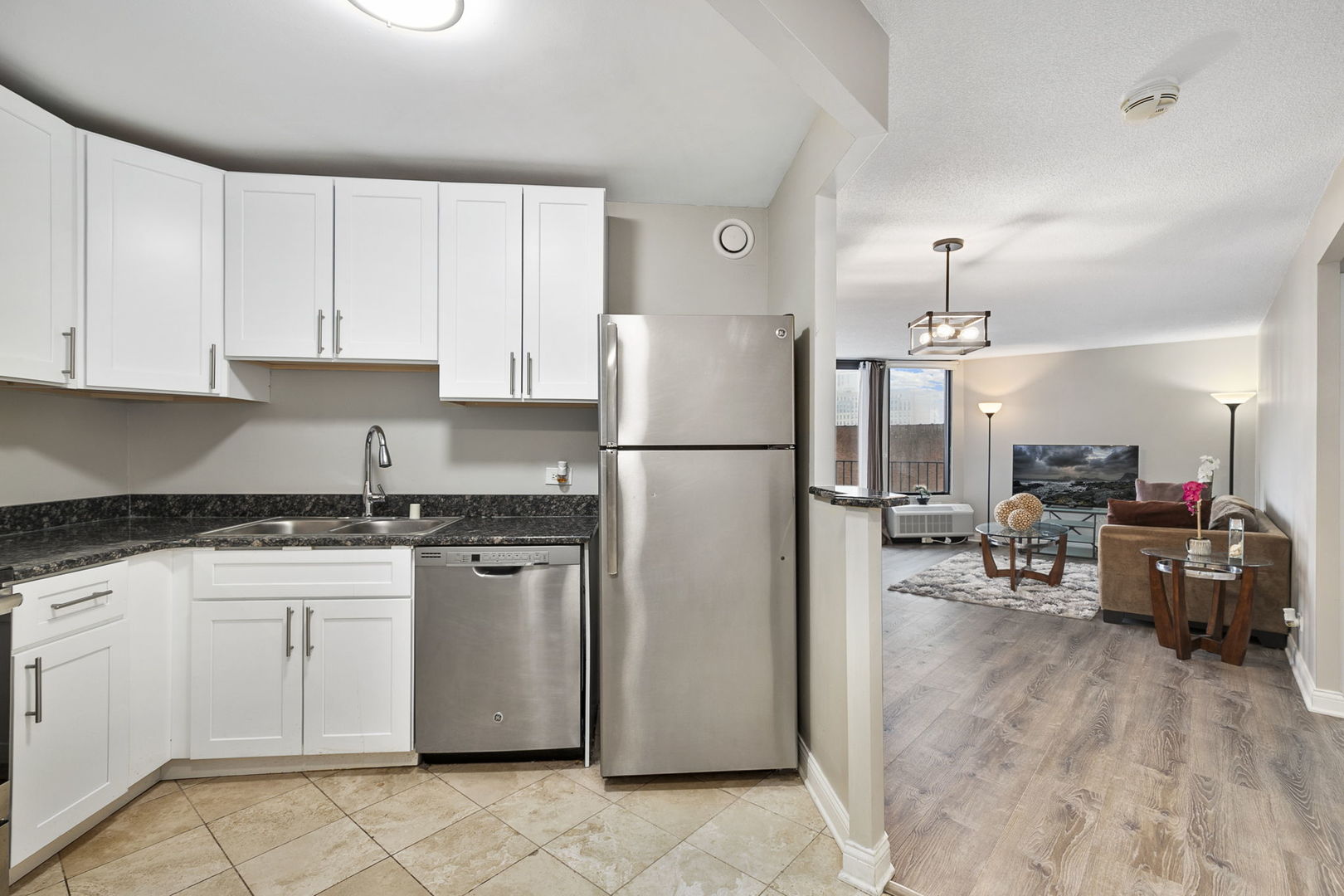 5320 North Sheridan Road, Unit 403 Chicago, IL 60640 - Photo 11 of 36 a kitchen with stainless steel appliances granite countertop a refrigerator a stove a sink dishwasher and a refrigerator with wooden floor
