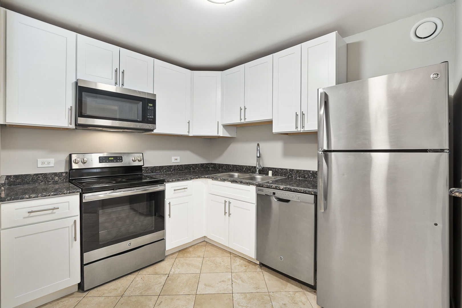 5320 North Sheridan Road, Unit 403 Chicago, IL 60640 - Photo 12 of 36 a kitchen with stainless steel appliances granite countertop a refrigerator stove a sink and a microwave