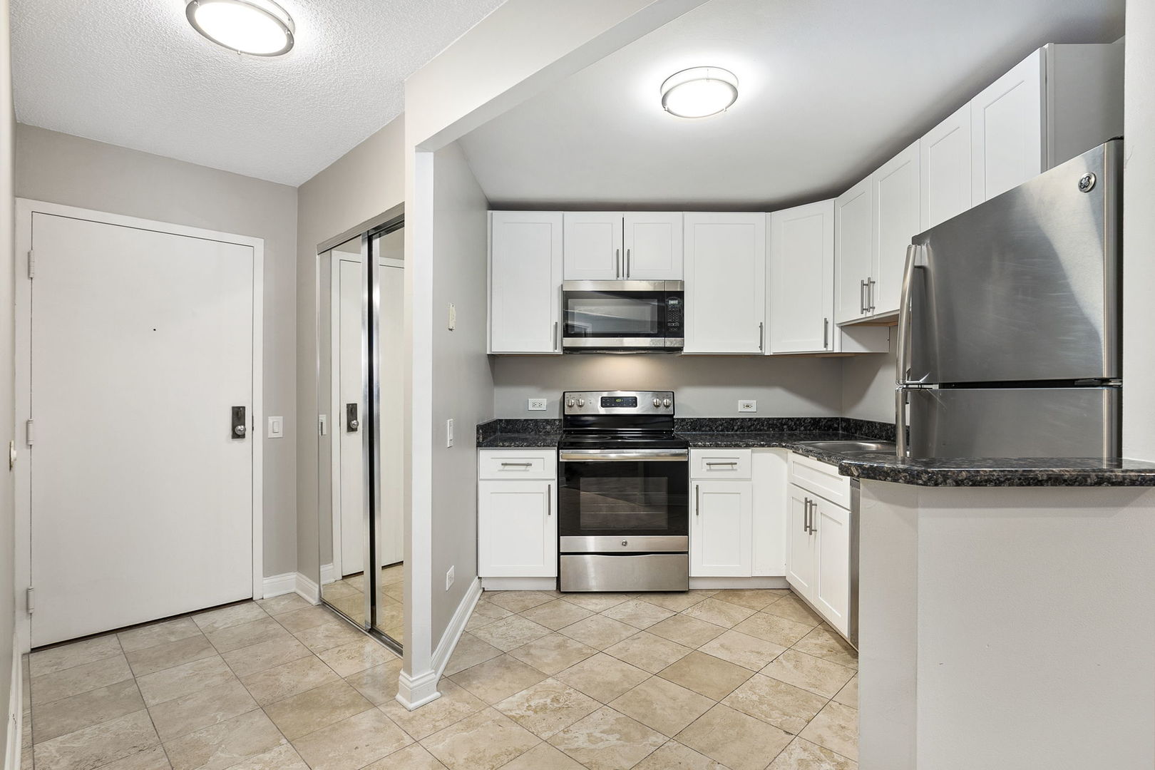 5320 North Sheridan Road, Unit 403 Chicago, IL 60640 - Photo 13 of 36 a kitchen with granite countertop a stove a sink and a refrigerator
